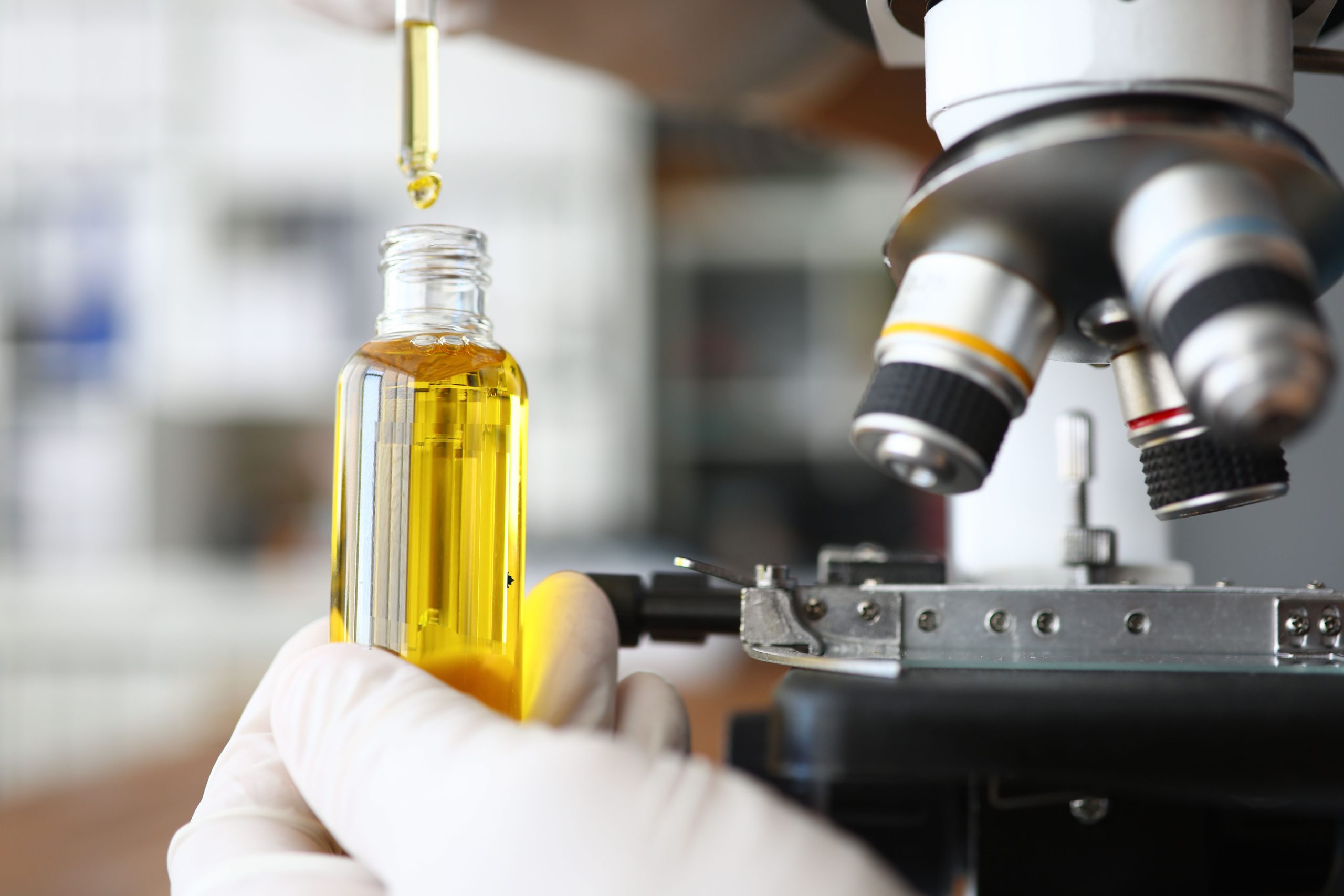 Ensuring the Safety of Medical Cannabis Products Focus on male hand holding glass bottle with cannabinoid oil.